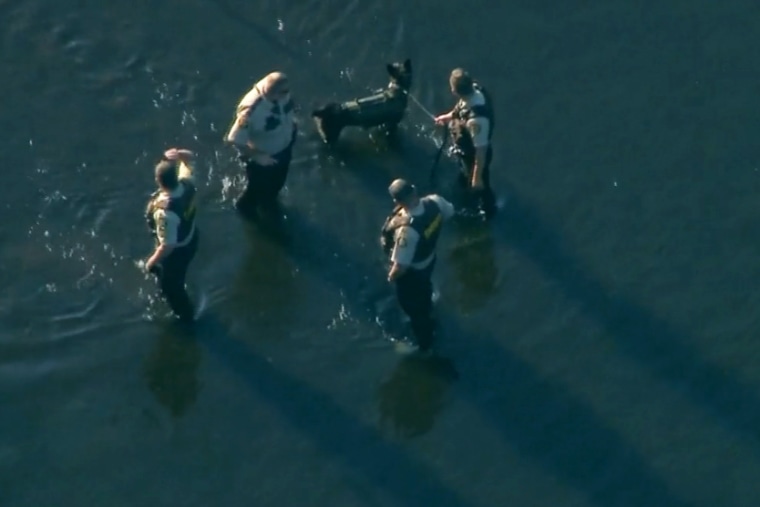 Officers investigate the stabbing of tubers along the Apple River in Wisconsin.