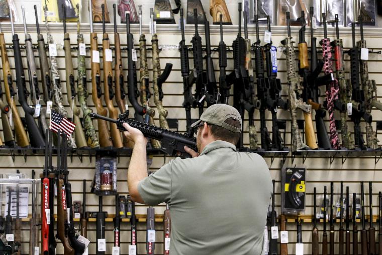 A customer holds an AR-15 riffle at a gun store in Orem, Utah, on Aug. 11, 2016.