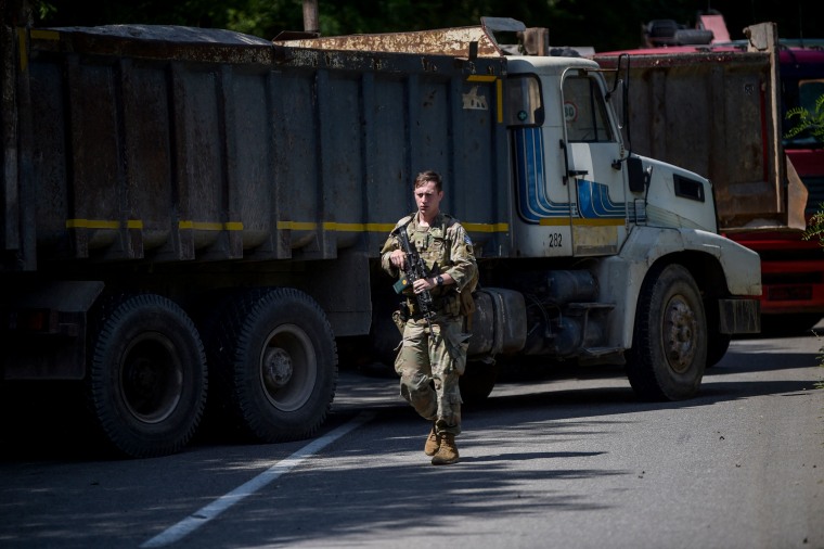 A US NATO soldier serving in Kosovo patrols next to a road barricade set up by ethnic Serbs near the town of Zubin Potok on Aug. 1, 2022.