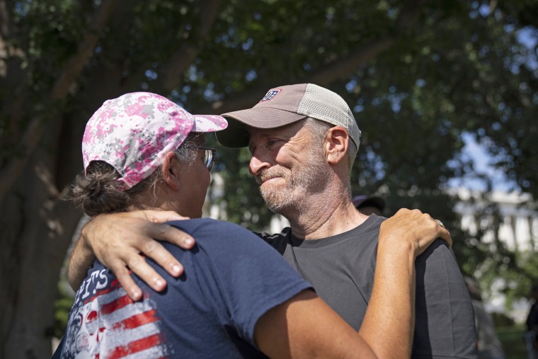Image: Comedian and activist Jon Stewart embraces Susan Zeier, mother-in-law of the late Sgt.  First Class Heath Robinson, before the Senate vote on the PACT Act outside the Capitol on August 2, 2022.
