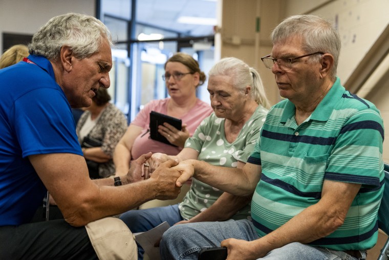 Image: Ronnie and Sue Combs pray in the Knott County Sportsplex on Aug. 2, 2022.