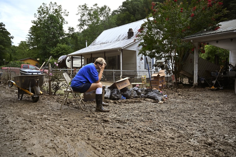 Image: Teresa Reynolds sits exhausted as members of her community clean the debris from their flood ravaged homes at Ogden Hollar in Hindman, Ky., on July 30, 2022.