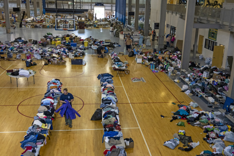 Image: A man organizes coats on the donation table at the Knott County Sportsplex on Aug. 2, 2022.