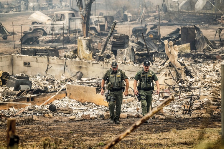 Sheriff's deputies leave a home where a McKinney Fire victim was found on Aug. 1, 2022, in Klamath National Forest, Calif.