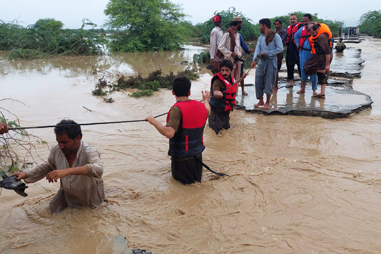 Rescue workers help villagers evacuate from flood waters