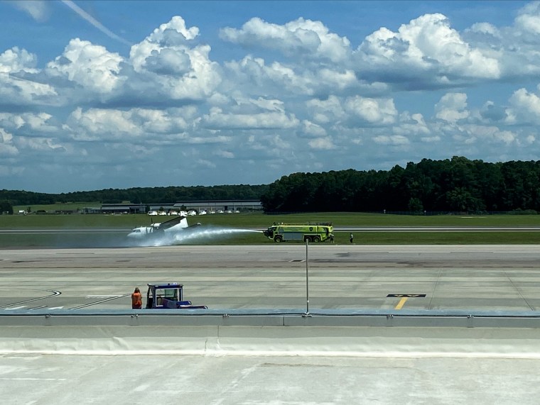 Emergency crews spraying water on the plane that skidded between runways at Raleigh's airport. 