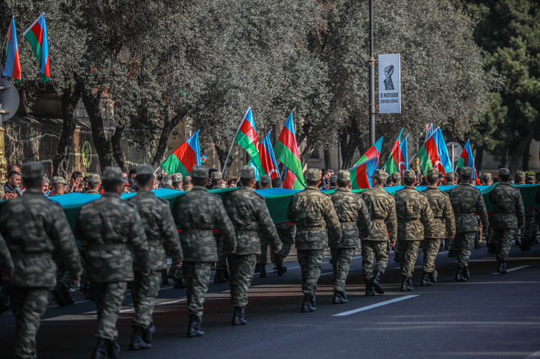 Image: Azeri service members carry a giant flag during a procession marking the anniversary of the end of the 2020 military conflict over Nagorno-Karabakh breakaway region on Nov. 8, 2021 in Baku, Azerbaijan.