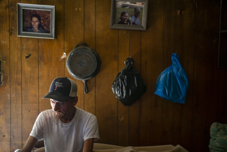 Dilbert White, 67, sits on the end of his cot where hes been sleeping since his house was wrecked during the flooding in Caney, Ky. on Aug 3, 2022. 