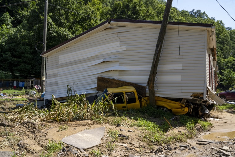 Image: A car remains crushed under a house that floated down River Caney Creek in Breathitt County, Ky. on Aug. 3, 2022.