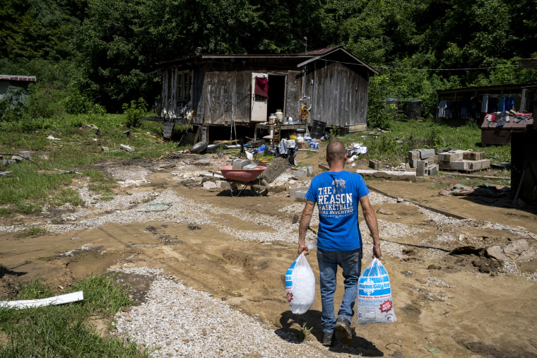 Image: James Henry White carries ice to his father in Caney, Ky. on Aug. 3, 2022.