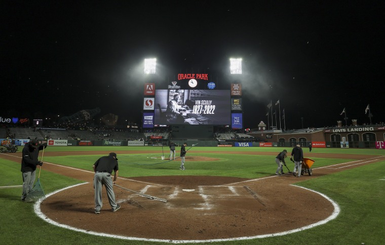 Image: The San Francisco Giants grounds crew works on the field after their game against the Los Angeles Dodgers as a tribute to Vin Scully is shown on video at Oracle Park on August 2, 2022 in San Francisco, Calif.
