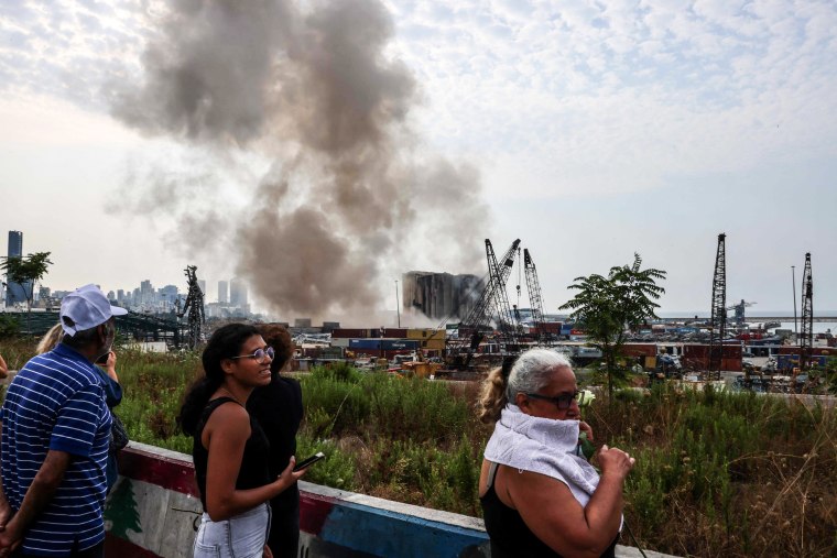 People gather as part of a grain silo at the port of Beirut collapses on August 4, 2022.