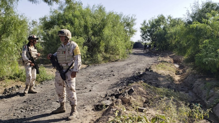 National Guards stand along the road that leads to where miners are trapped in a collapsed and flooded coal mine in Sabinas in Mexico's Coahuila state, on Aug. 4.