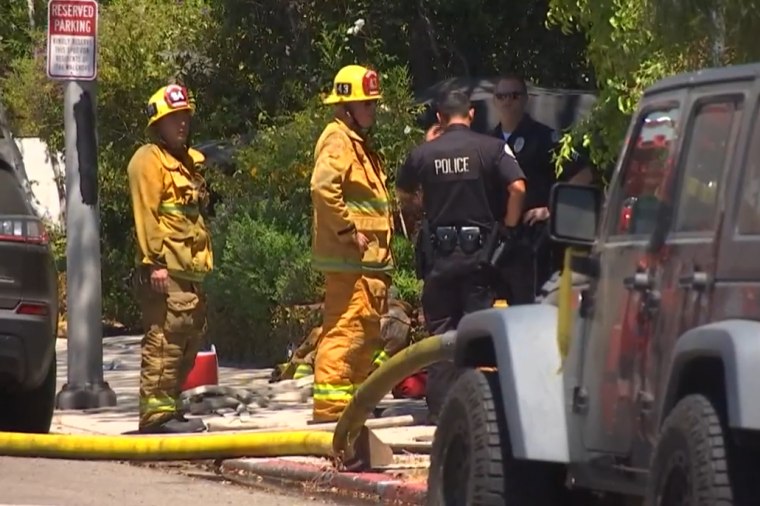 Police and firefighters investigate the scene of a car accident involving Anne Heche in Mar Vista, California, on Friday.