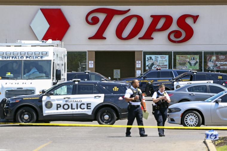 Police walk outside the Tops grocery store