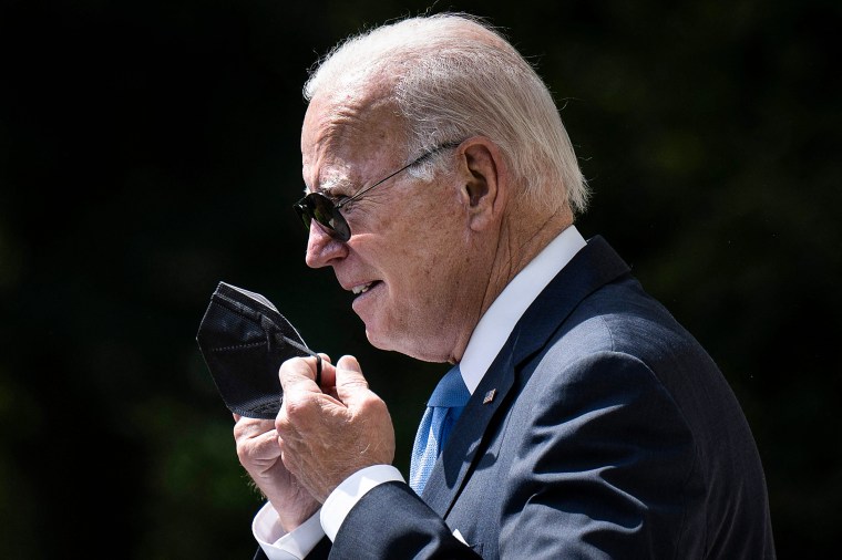 President Joe Biden removes his protective mask before speaking in the Rose Garden of the White House on July 27, 2022.