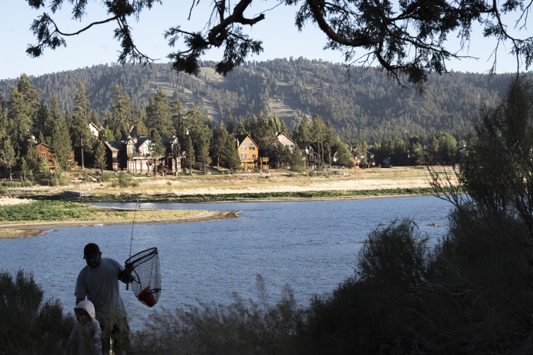 Image:  A father and child return to their car after fishing on Big Bear Lake on June 6, 2022.