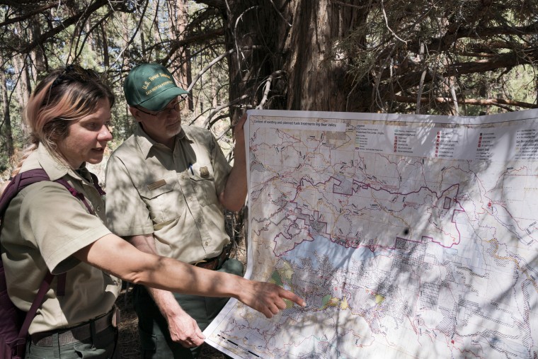 Image: Christina Barba, Fuels planner for the Mountaintop Ranger District of the San Bernardino National Forest, left, points to a map showing the different wildfire management projects around the Big Bear Lake area while Jason Collier, a NEPA Planner, looks on,
on June 6, 2022.