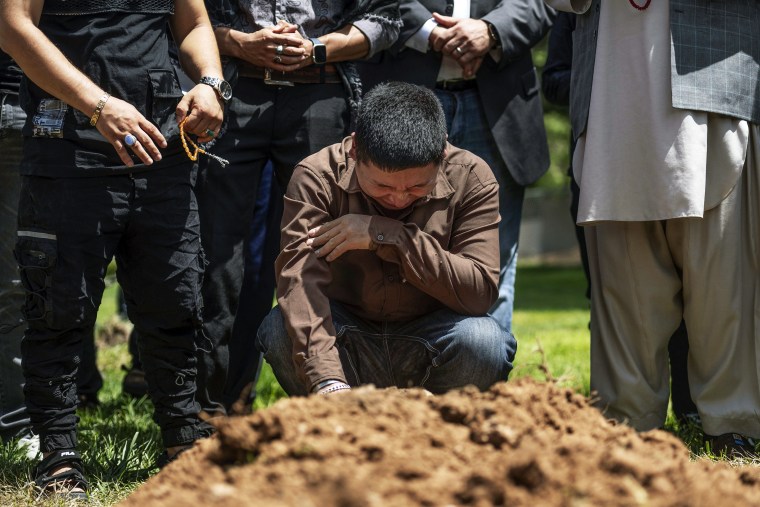 Altaf Hussain cries over the grave of his brother Aftab Hussein at Fairview Memorial Park in Albuquerque, N.M., on Aug. 5, 2022.