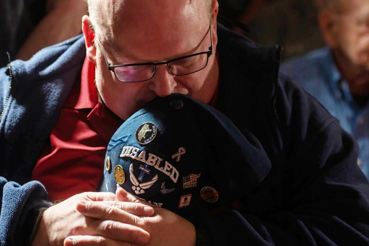 A disabled veteran bows his head in a prayer at the Ted Cruz