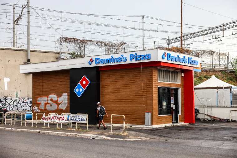 A "For Sale" banner is posted outside a closed-down Domino's Pizza store in Rome, Italy, on Aug. 9, 2022.