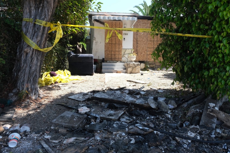 Charred debris and warning tape can be seen where Anne Heche crashed into a house