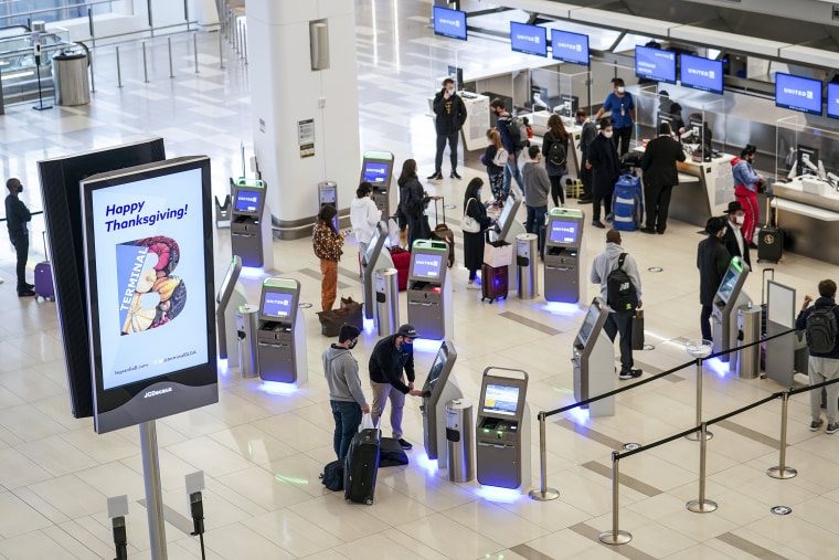 Travelers wait to check in for their flights at LaGuardia Airport in New York on Nov. 25, 2020.