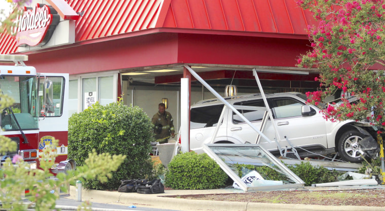 Firefighters inspect an SUV that crashed into a Hardee’s restaurant Sunday in Wilson, N.C.