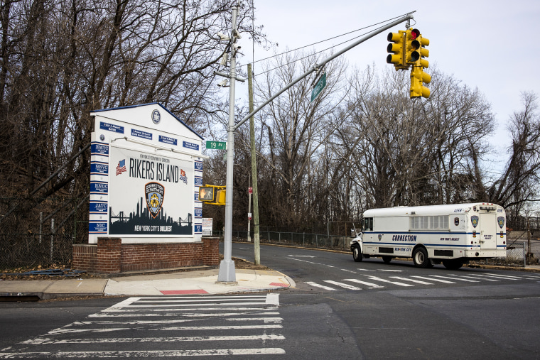 A Department of Corrections bus, used to transport prisoners, drives up to the entrance of the bridge that connects to Rikers Island, January 15, 2022 in Queens, N.Y.