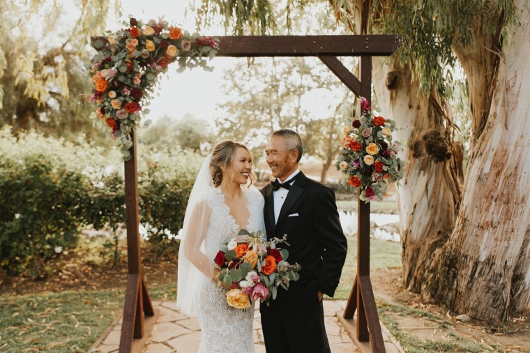 Brittany Revell poses with her father on her wedding day.