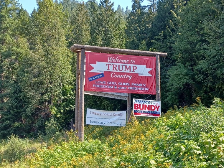 A sign demanding a recall of the library board hangs below a "Trump Country" sign in Bonners Ferry, Idaho.