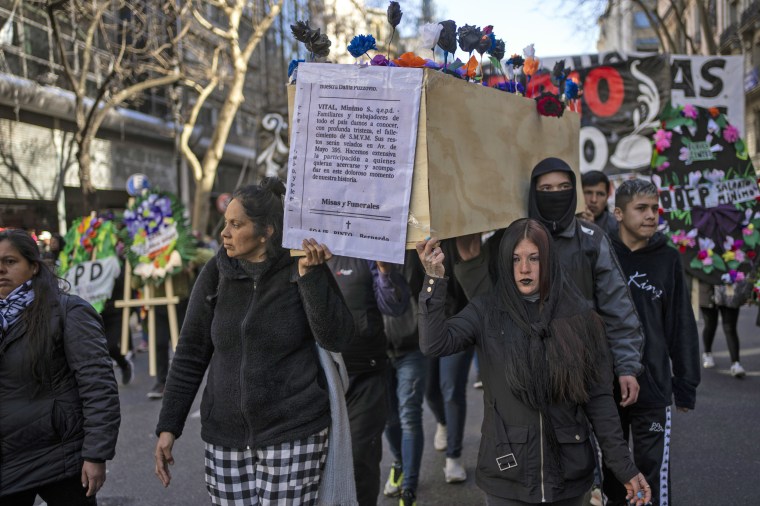 Protesters march with a mock coffin representing the death of a living wage in Buenos Aires, Argentina, on Aug. 19, 2022.