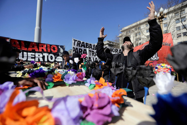 A protester gestures during a mock wake for the death of the salary