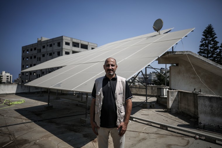 Sami Matar stands next to vital solar panels on the roof of the Central Blood Bank Society in Gaza City on Saturday.