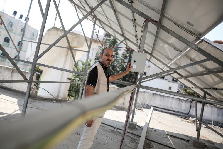 Sami Matar beneath vital solar panels on the roof of the Central Blood Bank Society in Gaza City on Saturday.