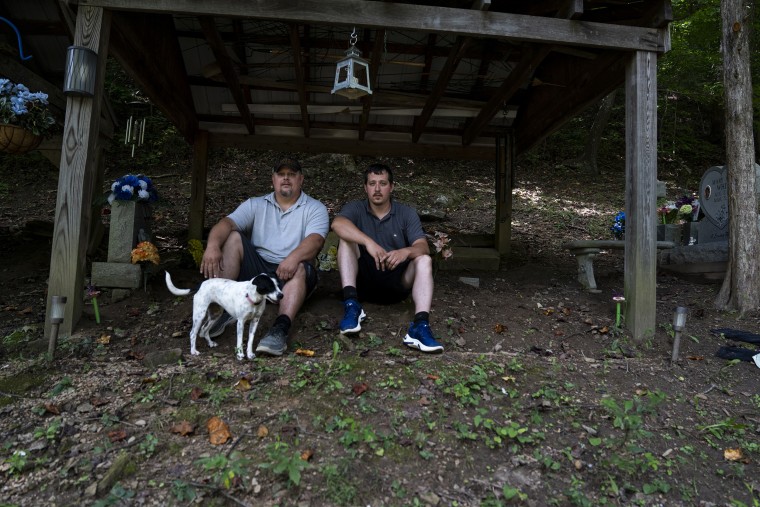 Image: Ashford White, 43, and Burley White, 28, in the family cemetery above their house, where they spent the night during the flooding that destroyed much of the River Caney community of Lost Creek on Aug. 18, 2022.