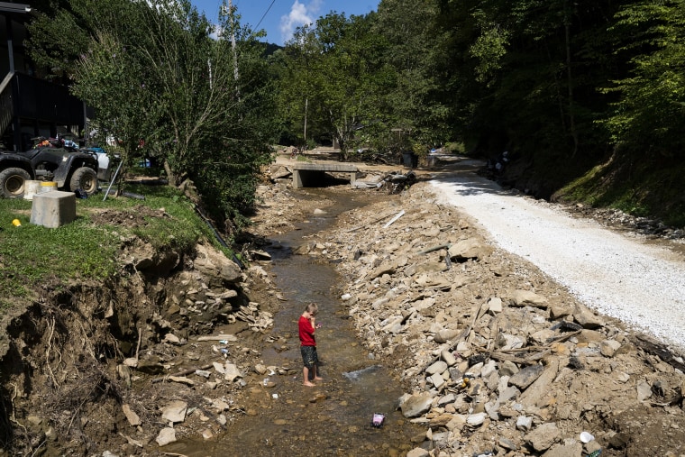Image: Hazen White, 7, plays in the creek that flooded the River Caney community of Lost Creek on August 18, 2022.