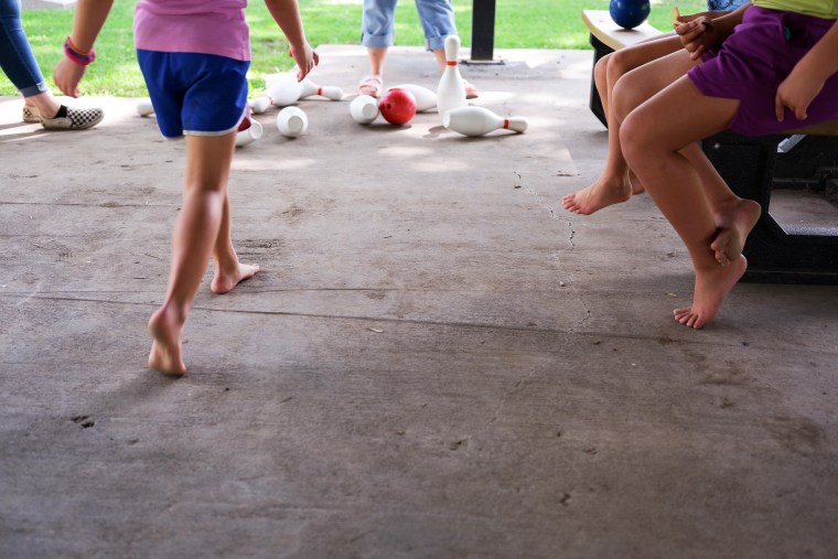 Image: Erin McAlvany's family plays at a meal site in Kirksville, Mo., on  Aug. 16, 2022.