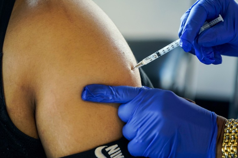 A health worker administers a Pfizer-BioNTech booster shot in Jackson, Miss., on Feb. 8, 2022.