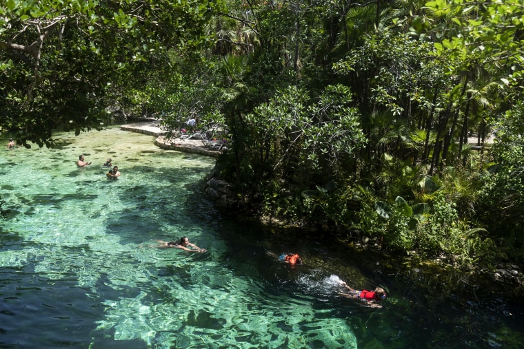 Tourists swim in a cenote, a natural deep-water well, in Playa del Carmen, one of the proposed stops along the Maya Train project in Quintana Roo state, Mexico, on Aug. 3, 2022.