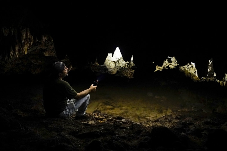 Archaeologist and cave diver Octavio Del Rio points his flashlight up toward the ceiling of the Guardianes cave, a flooded cavern that stretches for miles underneath the path of the planned Maya Train in Playa del Carmen, Quintana Roo state, Mexico, on Aug. 1, 2022.
