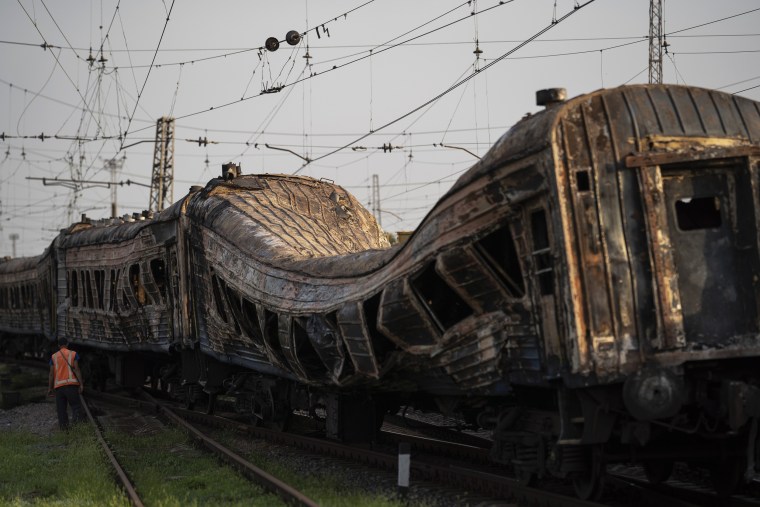 Image: A railway worker surveys a damaged train after an alleged Russian attack in the village of Chaplyne, Ukraine, on Aug. 25, 2022.