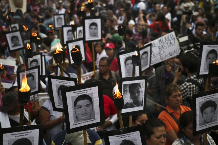 Image: The parents of 43 missing students from Ayotzinapa teachers school hold their portraits and torches during a march in Mexico City on April 26, 2016.