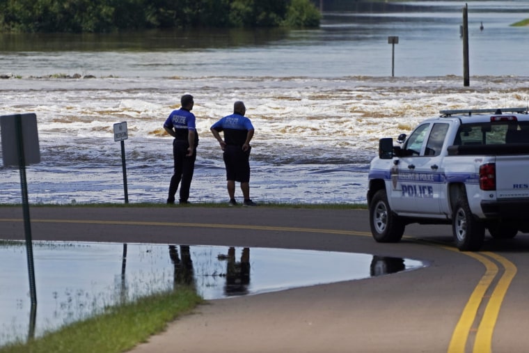 Police officers observe the release of water from the Ross Barnett Reservoir Spillway on the Pearl River, in Rankin County, Miss., on Sunday.