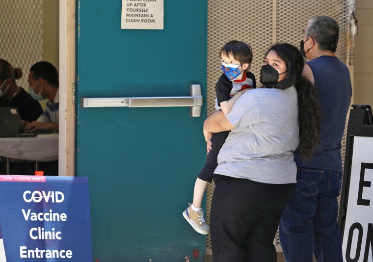 People wearing face masks wait at a Covid-19 vaccine clinic in Los Angeles on Aug. 5, 2022.