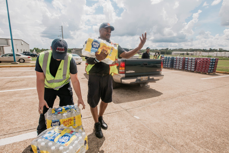 Members of the fire department distribute water at Hawkins Field Airport in Jackson, Miss., on Aug. 30, 2022.