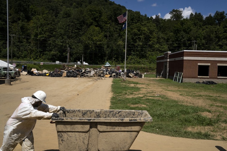 Image: Employees of Servpro, a restoration company, carry debris and contents of classrooms out of the Buckhorn School on Aug. 19, 2022, in Buckhorn, Ky.