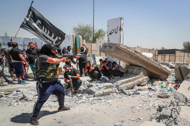 Image: Armed members of Saraya al-Salam (Peace Brigade), the military wing affiliated with Shiite cleric Moqtada al-Sadr, take aim during clashes with Iraqi security forces in Baghdad's Green Zone on Aug. 30, 2022.