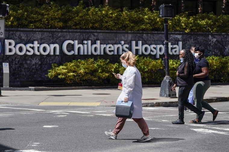 Pedestrians walk past a sign outside the Boston Children's Hospital on Aug. 18, 2022, in Boston.