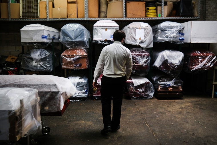 A funeral home employee tends tends to the inventory of pre-sold caskets on April 29, 2020, in New York.